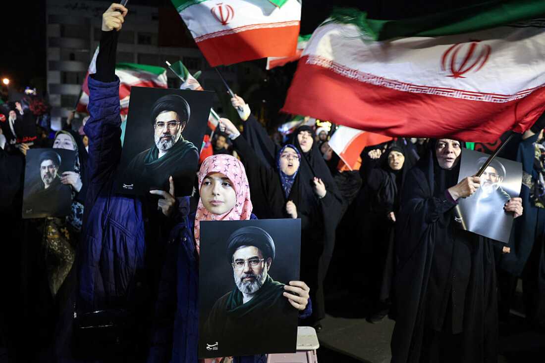 People wave Iranian flags and hold portraits of Supreme Leader Mojtaba Khamenei as they march in support of the Iranian armed forces in central Tehran on Wednesday.