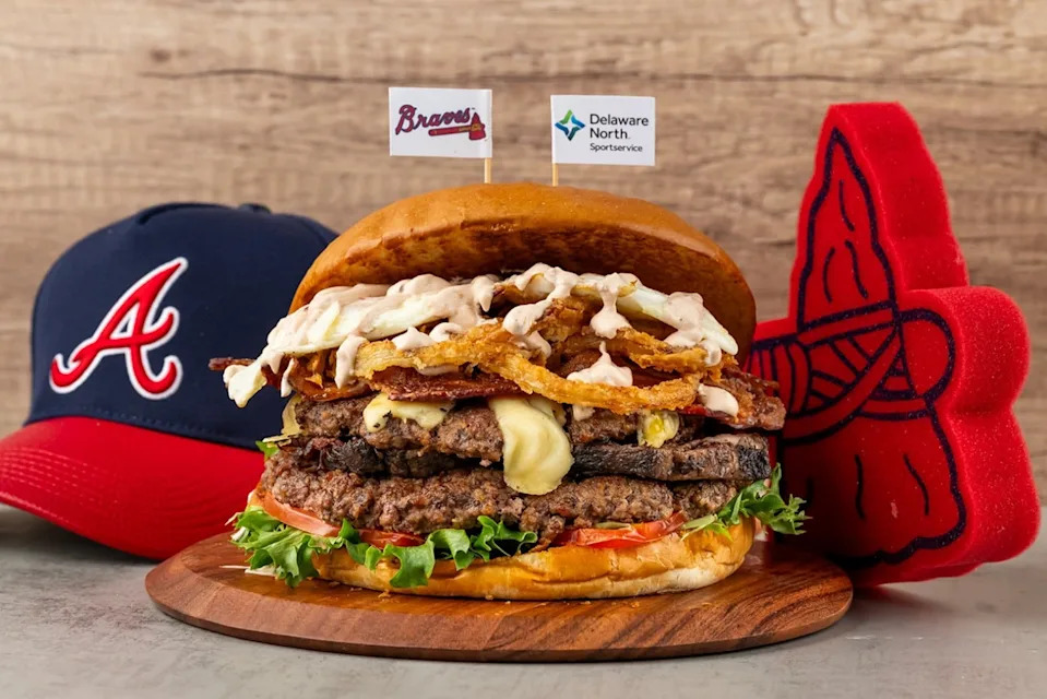 The Bat Flip (Section 113): Seven inches of toasted brioche stacked with two pounds of seasoned hand-formed beef patties, braised short rib, crispy pork belly, melted cheese, crunchy onions, green leaf lettuce, sliced red tomatoes and a fried egg.