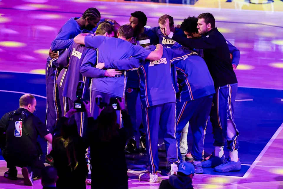 Luka Doncic #77 slaps Austin Reaves #15 of the Los Angeles Lakers on the head during the pregame huddle before an nba basketball game against the Brooklyn Nets, Friday March 27, 2026 in Los Angeles, Calif.