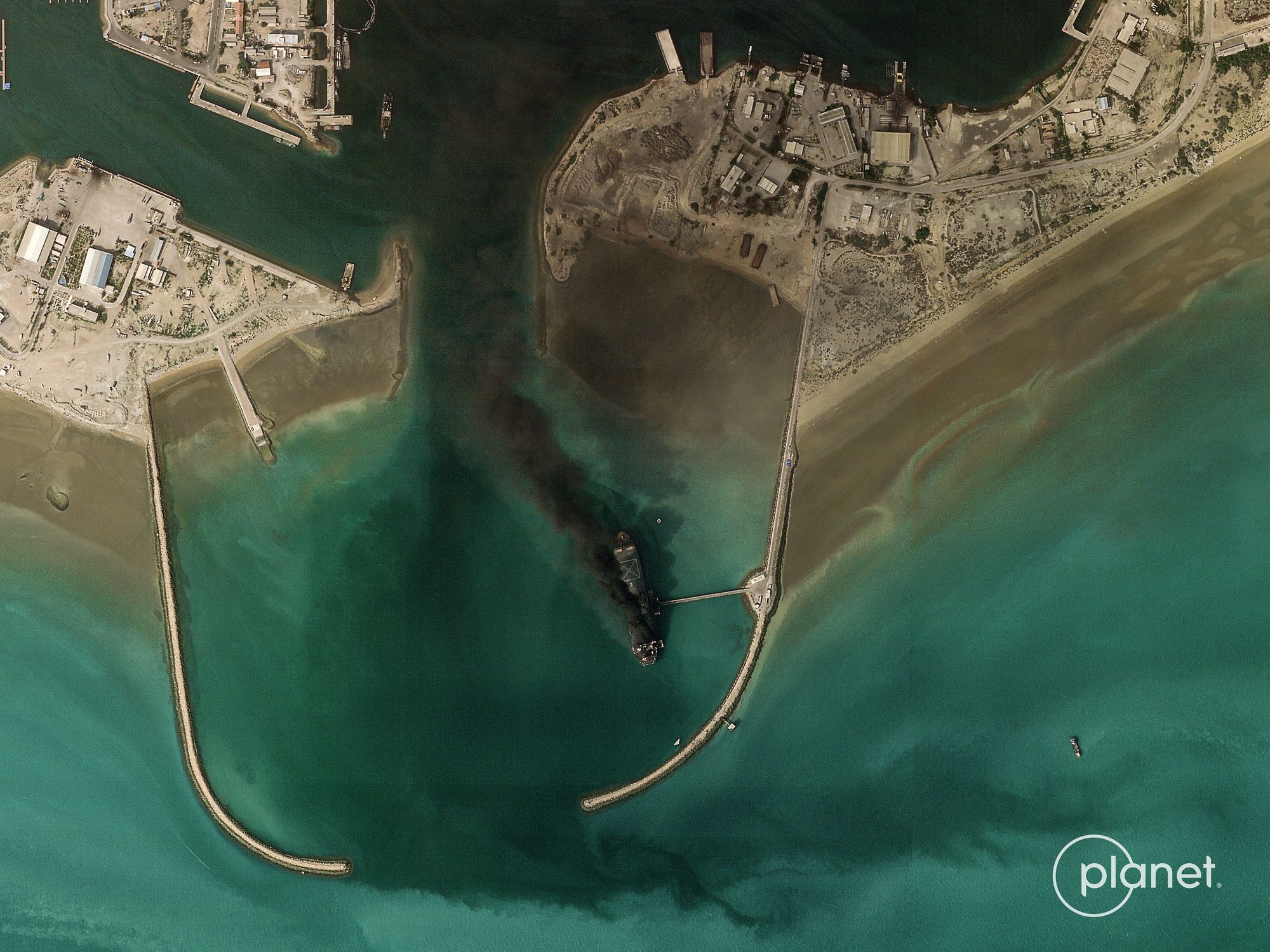 This handout satellite image taken by 2026 Planet Labs PBC on March 2, 2026 shows smoke billowing from a vessel following an explosion from the port of Bandar Abbas along the strait of Hormuz.