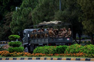 Army soldiers sit in a vehicle while patrolling in D Chowk near the President's House