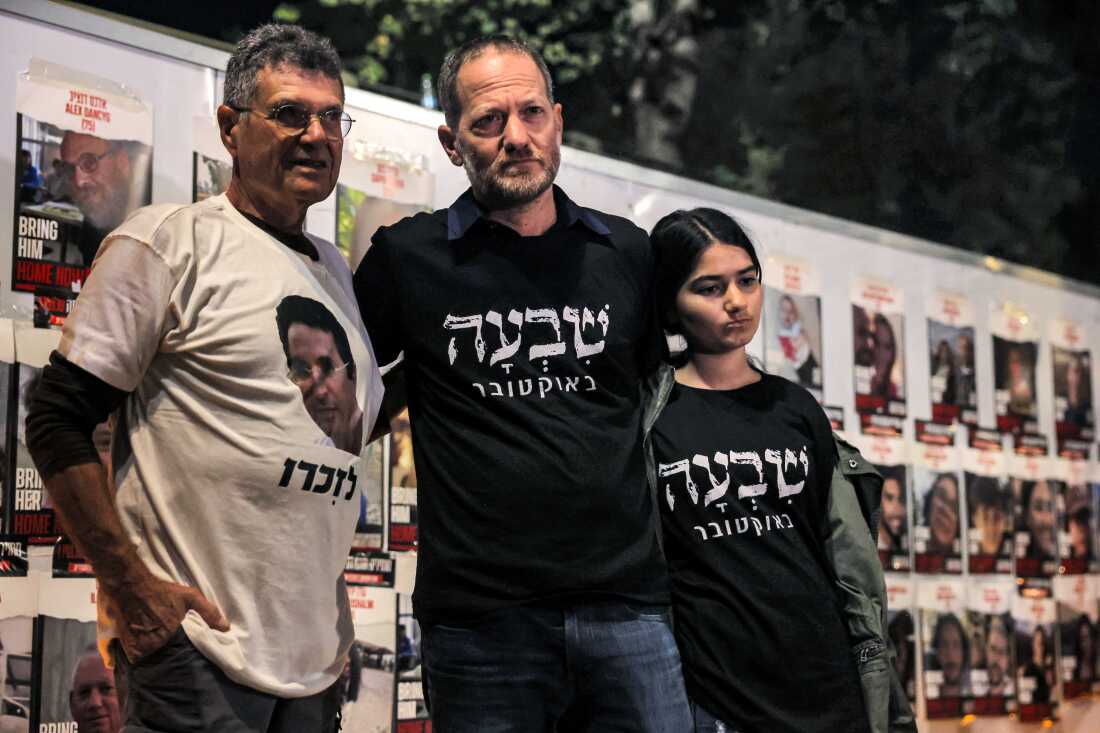 Maoz Inon (C), 48, whose parents died in the October 7 attack carried out by Palestinian militants from the Gaza Strip, stands alongside Yaakov Godo (L), 74, who also lost his son 