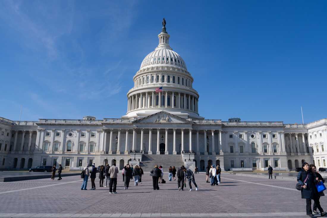 This photo shows the U.S. Capitol with its large dome. People are walking in front of it.