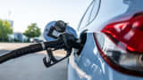 A fuel nozzle is inserted into a combustion engine at a petrol pump at a filling station during a refueling process.