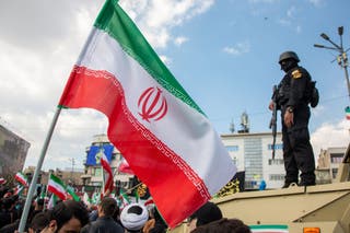 Ssecurity forces watch over the crowd during a funeral procession held for IRGC navy chief Alireza Tangsiri