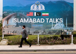 A man walks past a billboard near the media centre in Islamabad
