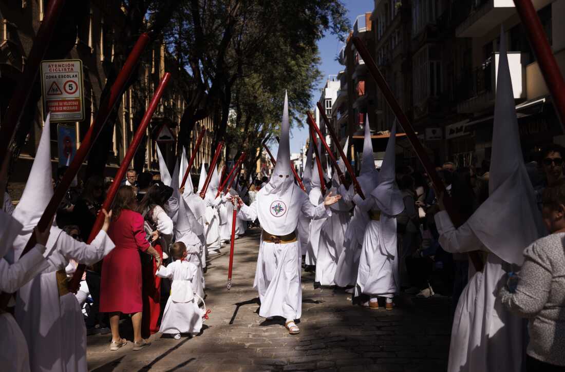 Penitents from the La Paz brotherhood parade in the Palm Sunday procession in Seville 