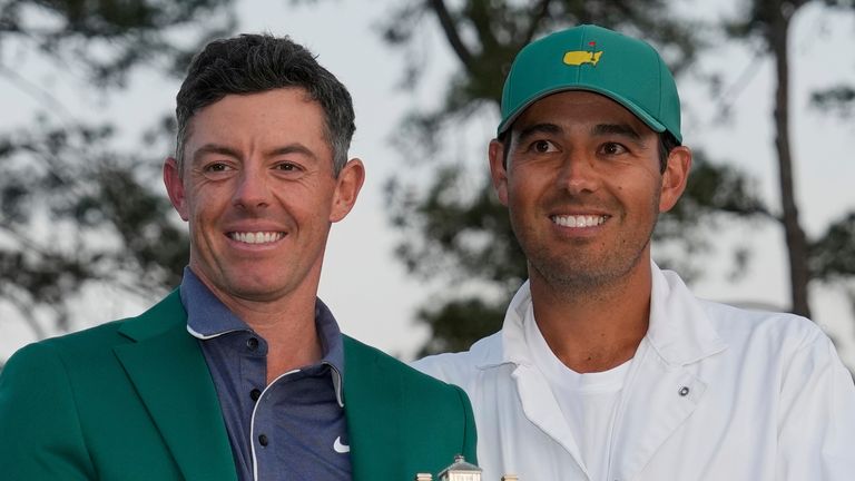 Rory McIlroy, of Northern Ireland, holds the trophy with caddie Harry Diamond after winning The MAsters